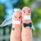 Fingers art of happy couple in medical mask from COVID-2019. Concept of wedding ceremony.
